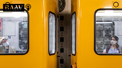 Zwei getrennte Menschen mit Maske in der U-Bahn